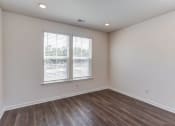 Thumbnail 21 of 45 - an empty living room with wood flooring and two windows