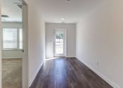Thumbnail 20 of 45 - a living room with white walls and wood flooring and a door