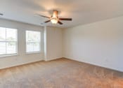 Thumbnail 16 of 45 - an empty living room with a ceiling fan and two windows