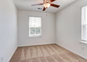 Thumbnail 10 of 45 - an empty room with a ceiling fan and two windows