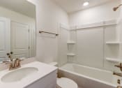 Thumbnail 36 of 45 - a bathroom with a sink and a tub and a mirror