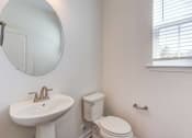 Thumbnail 34 of 45 - a bathroom with a sink and a toilet and a mirror