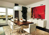 Thumbnail 10 of 29 - A modern dining room with a wooden table and white chairs.