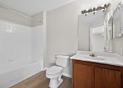 Thumbnail 12 of 32 - A white toilet sits next to a sink in a bathroom.