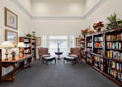 Thumbnail 16 of 32 - A room filled with bookshelves and a table with chairs.