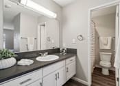 Thumbnail 17 of 32 - A bathroom with a white sink and a toilet.