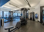 Thumbnail 19 of 24 - A gym with a variety of equipment including treadmills, weights, and exercise machines.