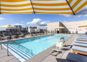 Thumbnail 10 of 29 - Rooftop pool with lounge chairs and city views