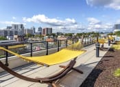 Thumbnail 37 of 46 - Yellow hammock on pool deck with views of skyline