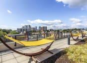 Thumbnail 14 of 29 - Rooftop outdoor space with hammocks and city views