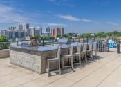 Thumbnail 29 of 46 - a bar with chairs and tables on a rooftop overlooking the city