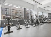 Thumbnail 18 of 46 - a gym with cardio equipment and windows in a building