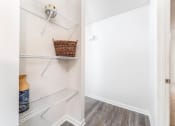 Thumbnail 12 of 20 - a walk in closet with shelves and a basket on the wall