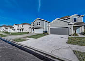 Thumbnail 19 of 21 - a row of houses on a street with a blue sky in the background
