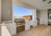 Thumbnail 43 of 56 - a large outdoor kitchen with a grill and a window