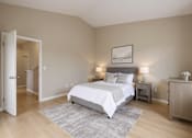 Thumbnail 5 of 51 - A bedroom with a large bed and a nightstand with a lamp.