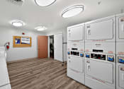 Thumbnail 27 of 32 - A laundry room with washers and dryers.