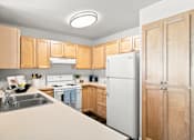 Thumbnail 6 of 47 - A kitchen with wooden cabinets and a white refrigerator.