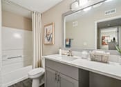 Thumbnail 15 of 34 - A bathroom with a toilet, sink, and mirror.