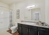Thumbnail 13 of 39 - A bathroom with a white toilet, a white sink, and a white bathtub.
