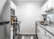 Thumbnail 14 of 20 - a kitchen with granite counter tops and stainless steel appliances