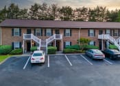 Thumbnail 14 of 17 - an apartment building with cars parked in front of it