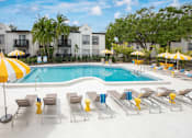 Thumbnail 5 of 34 - A pool surrounded by yellow umbrellas and lounge chairs.