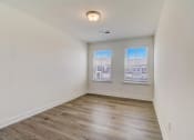 Thumbnail 6 of 20 - a bedroom with hardwood floors and two windows