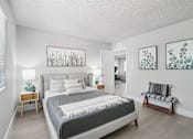 Thumbnail 7 of 34 - One-Bedroom Apartments in North Mountain Village, Phoenix, AZ - Ardella on 28th - Spacious Bedroom With Upholstered Bed, Side Tables, Lamps, Soft Gray Bedding, Bed Bench, and Large Window With Blinds.
