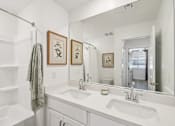 Thumbnail 19 of 45 - A bathroom with a white tub, sink, and towel.