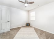 Thumbnail 15 of 20 - an empty living room with a ceiling fan and a rug