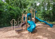 Thumbnail 4 of 25 - Sandy Springs, GA Apartments – Celebration at Sandy Springs - a playground with a blue slide and wooden steps