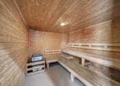 Thumbnail 39 of 47 - A wooden sauna room with benches and a table.