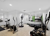 Thumbnail 17 of 32 - A room with a treadmill, elliptical trainer and other exercise equipment.