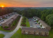 Thumbnail 16 of 17 - an aerial view of a parking lot and buildings at sunset