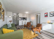 Thumbnail 1 of 20 - Living room at Idlewild 45 Apartments in Memphis TN featuring modern furnishings, large windows, and wood-style flooring