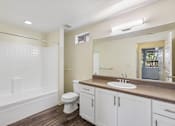 Thumbnail 12 of 24 - A bathroom with a white toilet and sink.