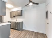 Thumbnail 17 of 23 - a kitchen and living room in an apartment with a ceiling fan