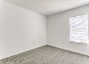 Thumbnail 21 of 23 - a bedroom with a window and a carpeted floor