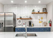 Thumbnail 1 of 23 - a kitchen with white countertops and blue cabinets