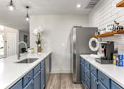 Thumbnail 3 of 23 - a kitchen with white countertops and blue cabinets