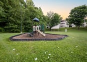 Thumbnail 17 of 20 - a playground with a swing set in a park