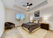Thumbnail 17 of 30 - Boatman Hammock Townhomes in Lake Worth, FL photo of  a bedroom with a large bed and a ceiling fan