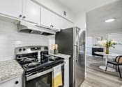 Thumbnail 29 of 34 - A modern kitchen with a black stove top oven and a black refrigerator.