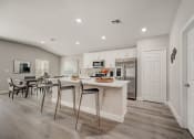 Thumbnail 15 of 29 - Houses in Lady Lake for Rent – The Groves at Lake Ella - a luxury kitchen with a island and a dining table with chairs