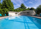 Thumbnail 18 of 20 - a swimming pool with chairs and a house in the background