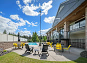 Thumbnail 30 of 47 - A modern outdoor patio with yellow chairs and a pool.