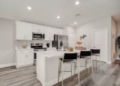 Thumbnail 16 of 29 - Lady Lake, FL Rentals – The Groves at Lake Ella -  luxury open kitchen with a large island with three stools