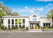 Thumbnail 1 of 34 - A white building with a blue sign that reads "Pet Friendly" is surrounded by greenery.