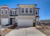Thumbnail 20 of 20 - a house with a white garage door in front of a blue sky